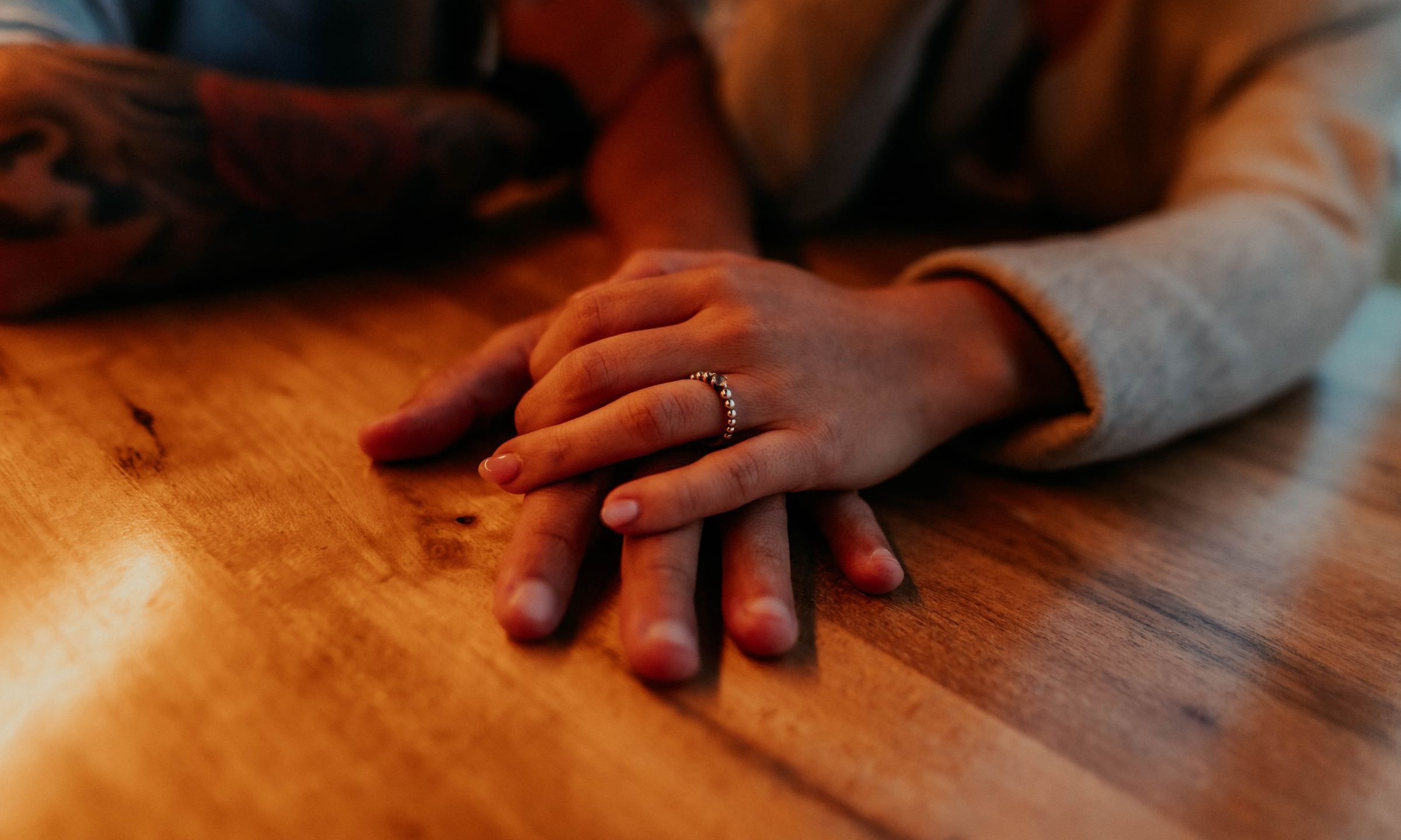 Two hands clasped on a table