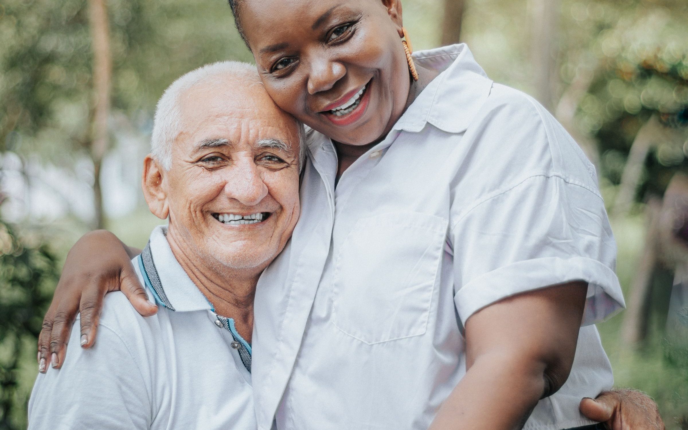 An older couple embracing and smiling together in a park